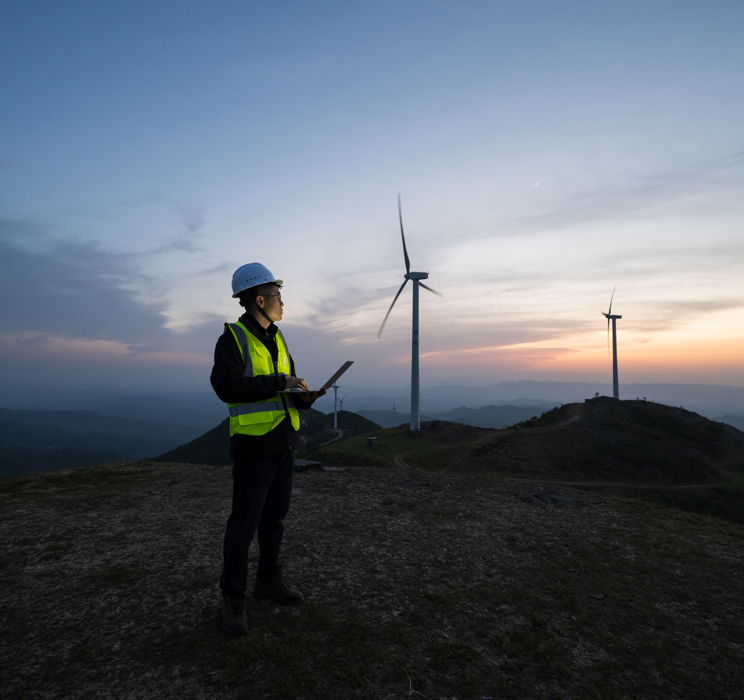 Technician standing in front of wind turbines